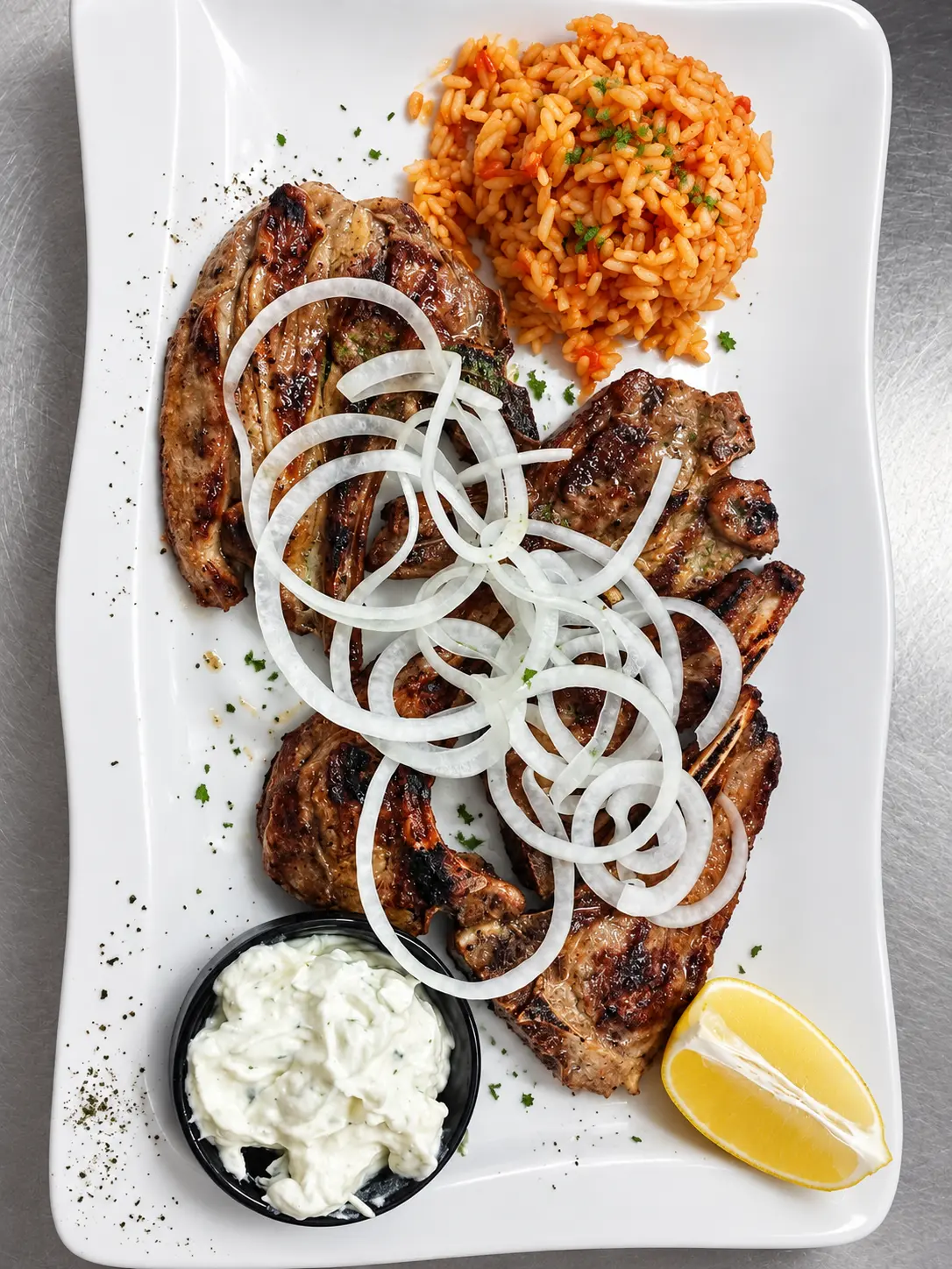 Paidakia – gegrillte Lammkoteletts mit Zwiebeln, Reis und Tzatziki.