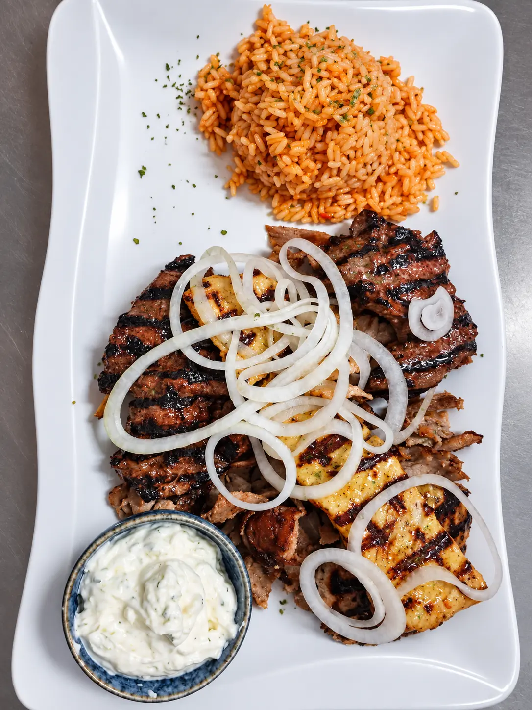 Kreta-Teller mit Gyros, Bifteki, Souvlaki, Zwiebeln, Reis und Tzatziki.